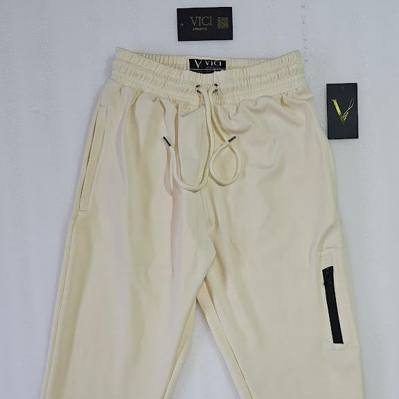 Beige pants with black accents on a white background, featuring VICI branding.